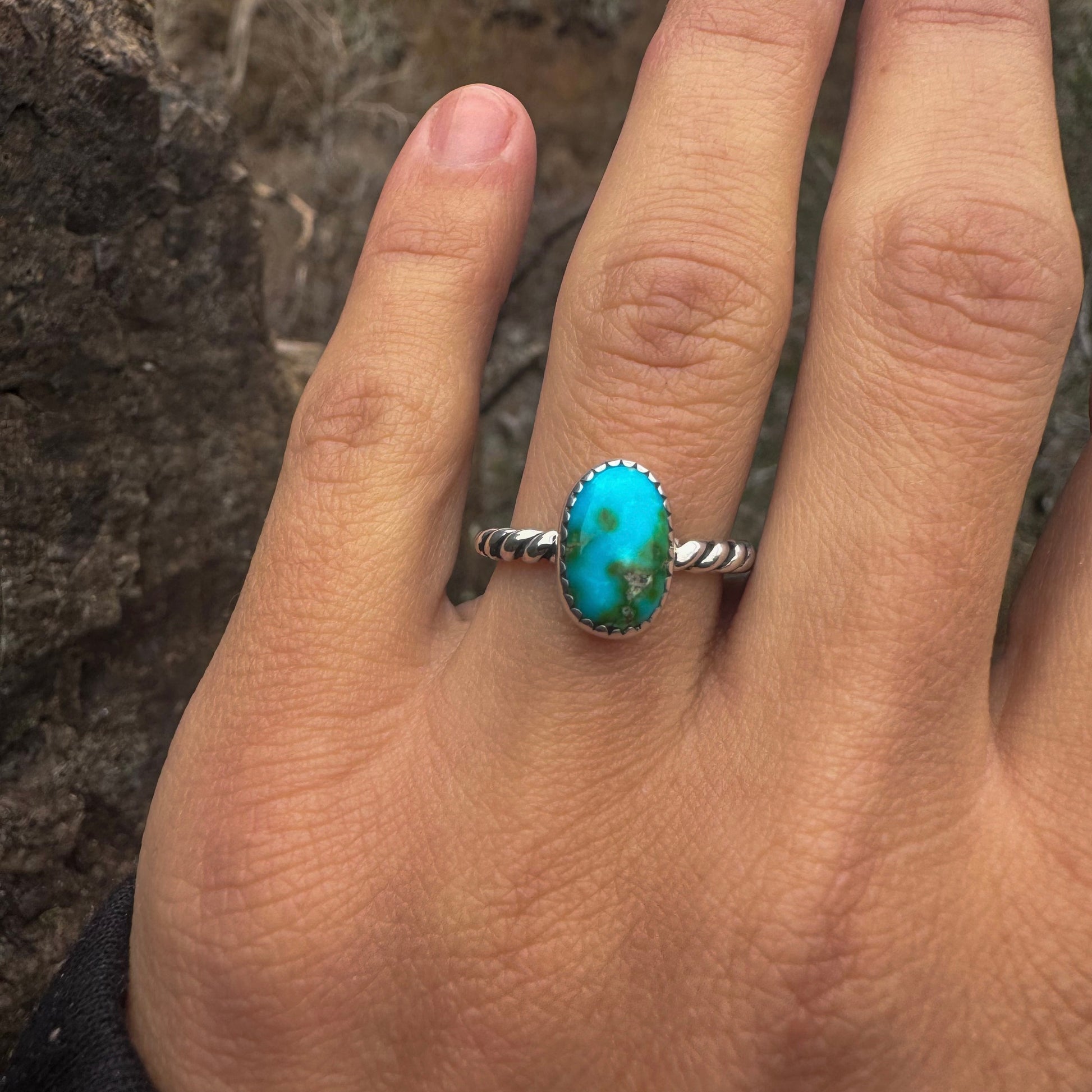 Turquoise ring on a person's finger with a natural background