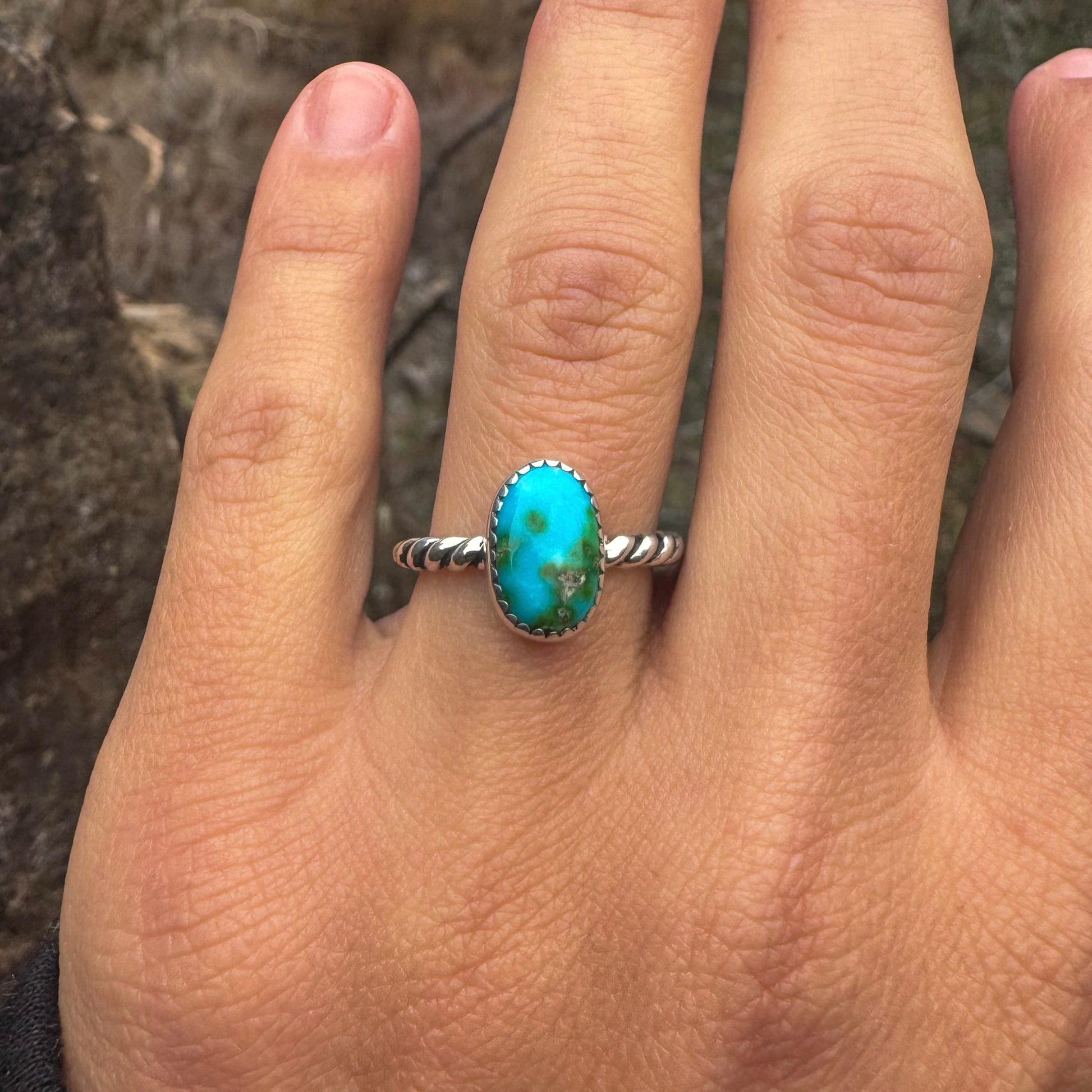 Turquoise ring on a person's finger with a natural background